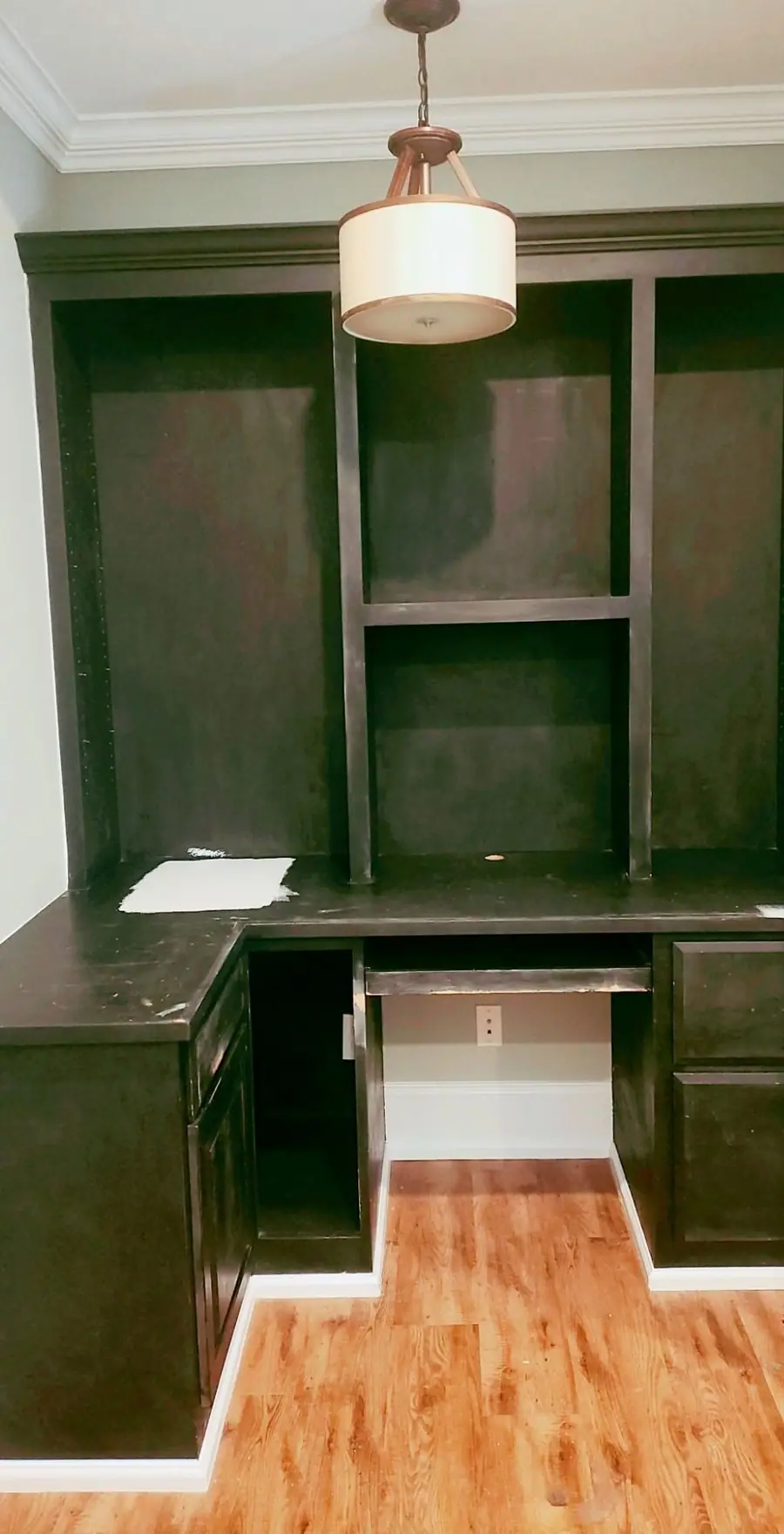 Built-in desk and shelving in a dark espresso finish before painting