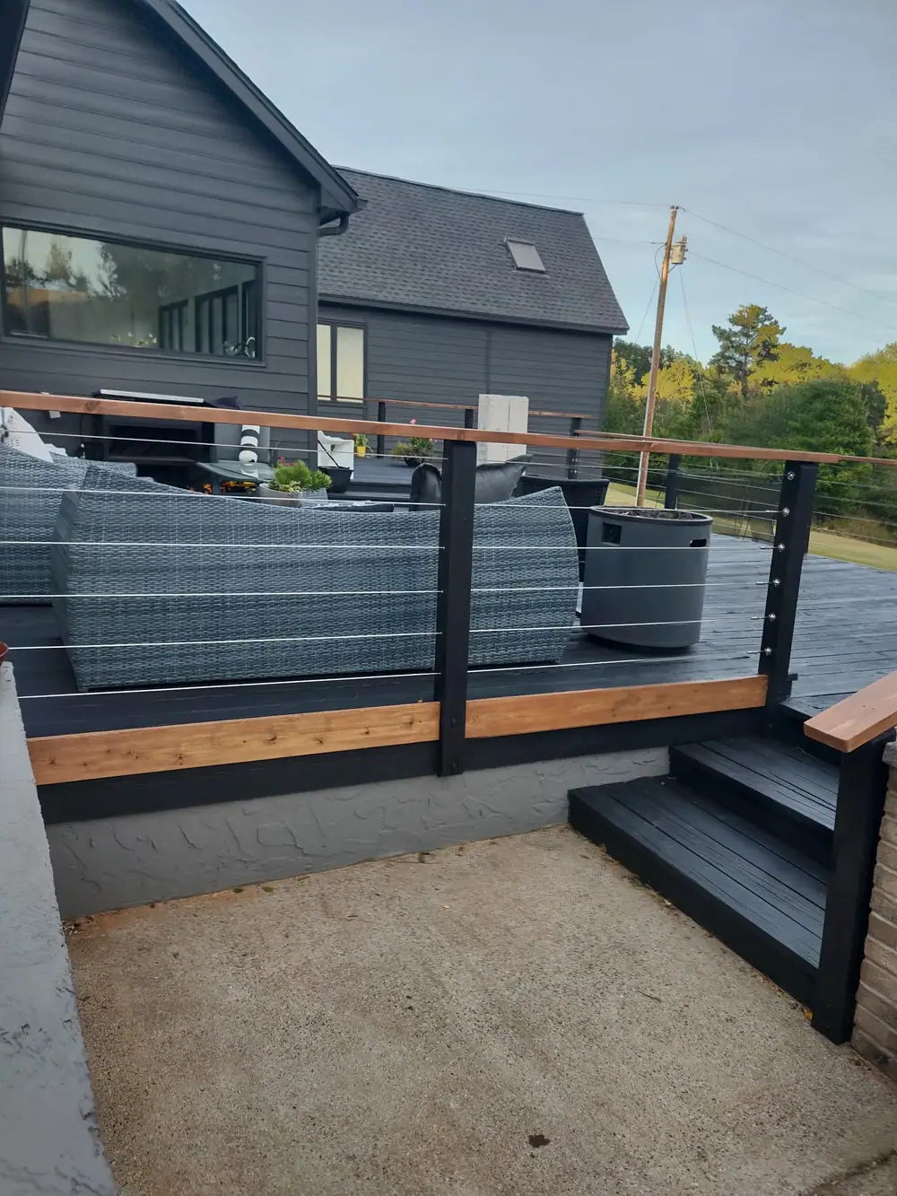 Deck finished in dark gray with a natural cedar cap rail and cable railing