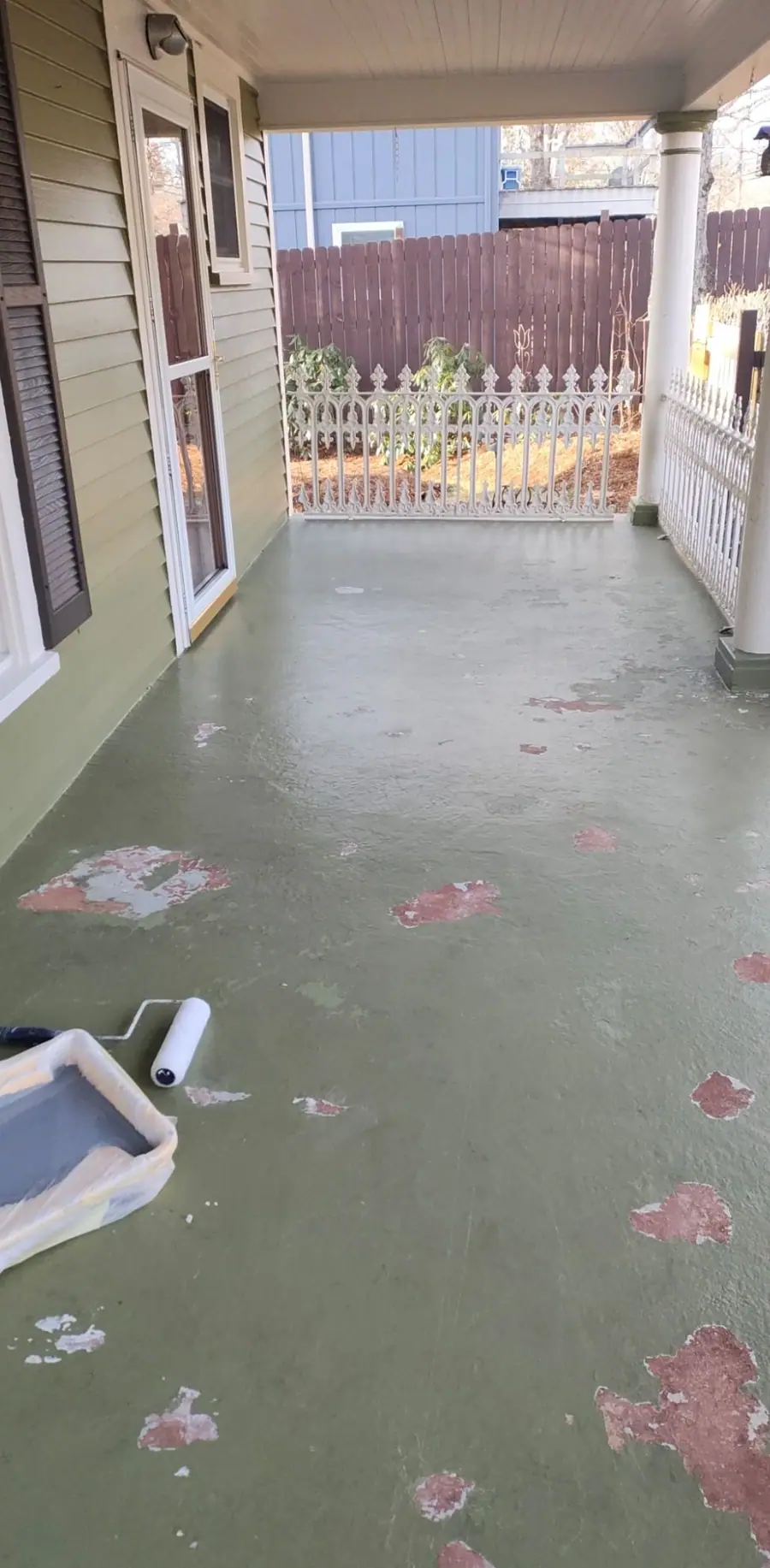 Porch floor before the job, with green paint peeling away in patches