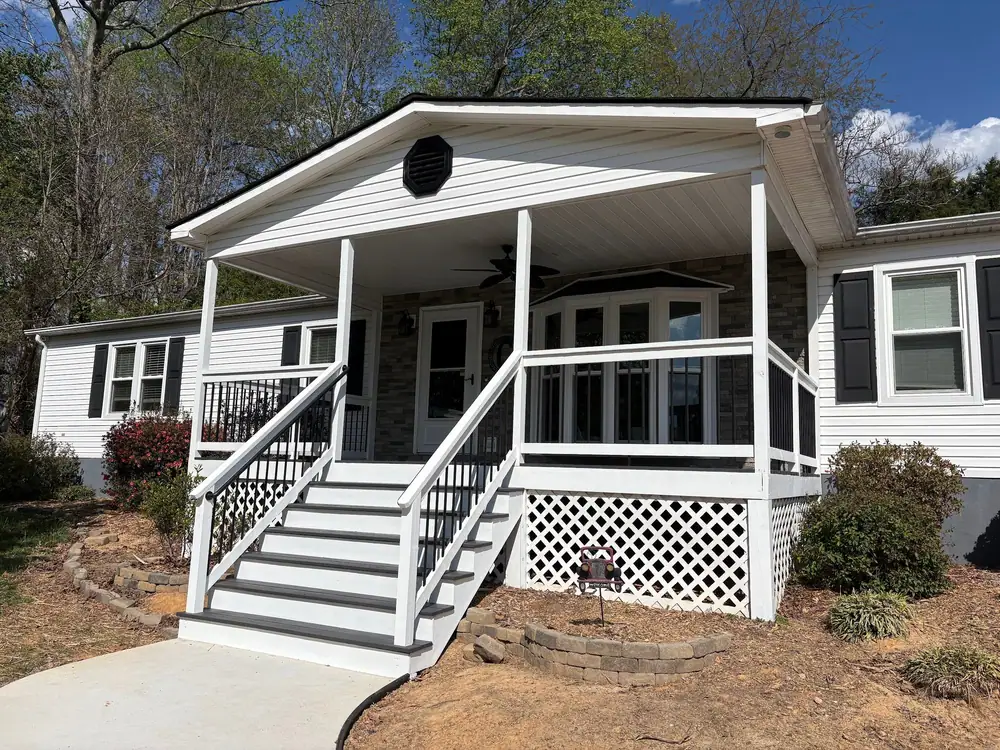 Covered front porch with white railings, black balusters and gray and white stairs