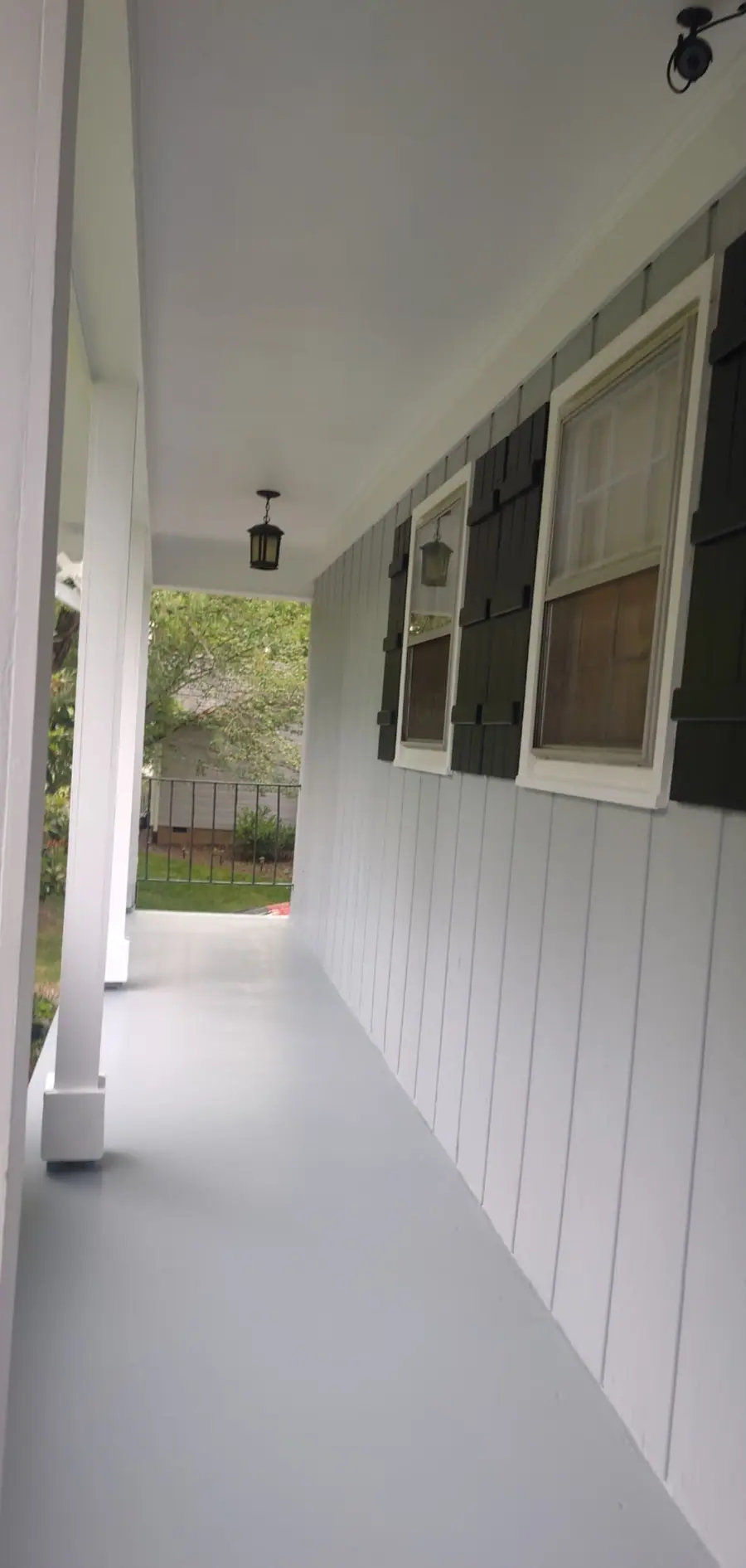 Side porch after, with the floor painted gray and the siding painted white